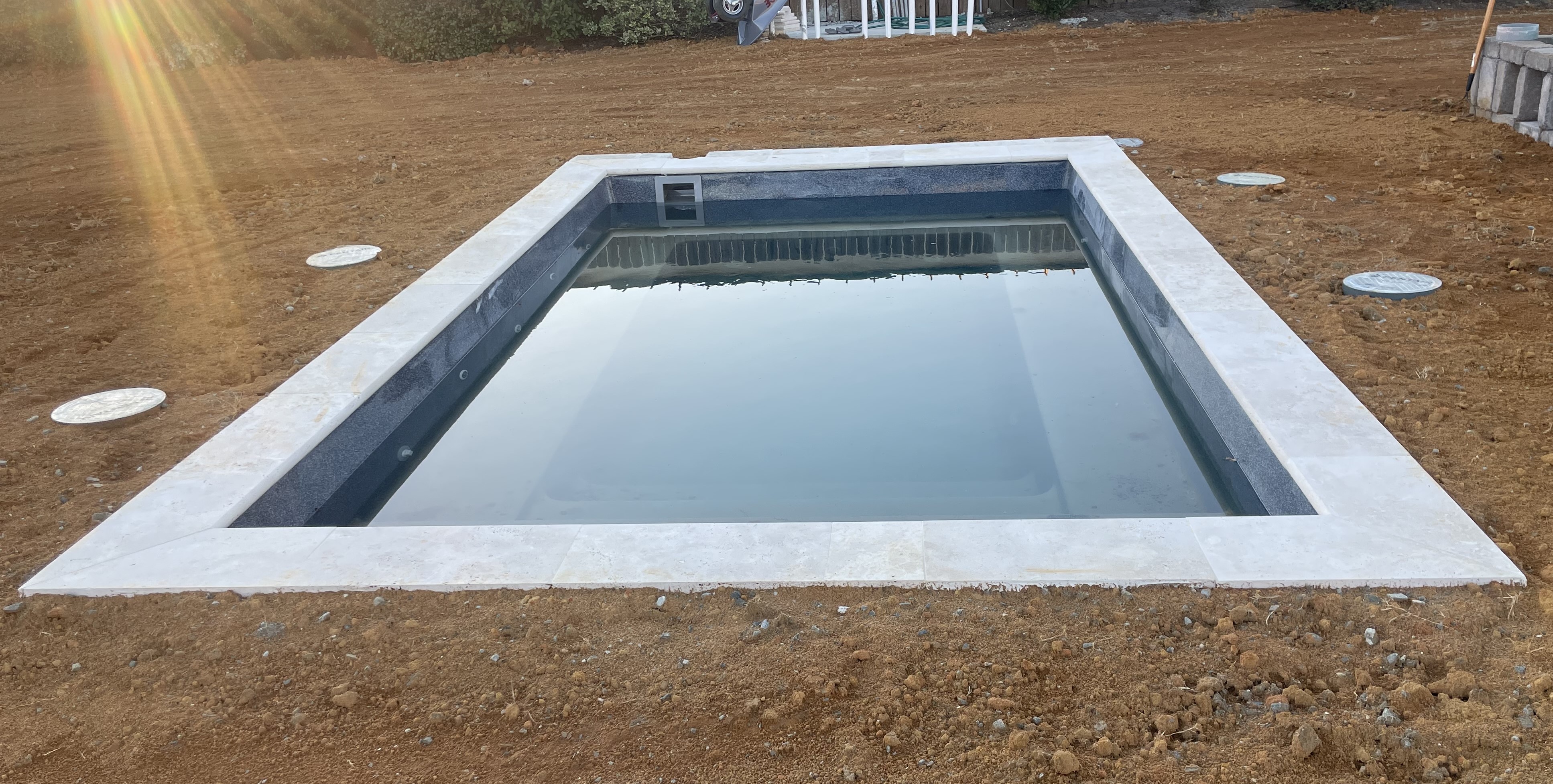After fiberglass pool is set with plumbing and filled with water